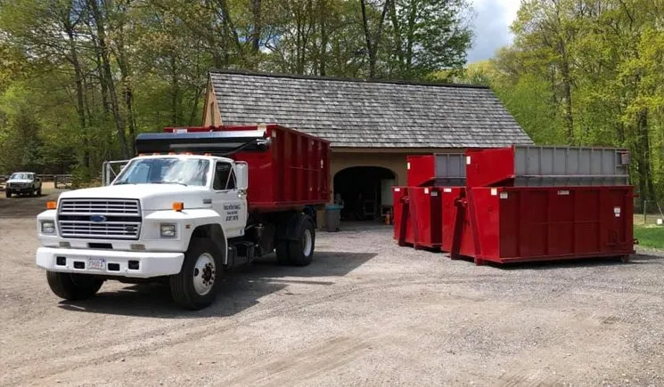 Roll-off dumpster on a residential driveway during a house cleanout in Central Massachusetts